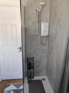 a shower with a glass door in a bathroom at Self-catering in Portree in Portree