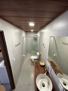 ein Bad mit einem WC, einem Waschbecken und einer Dusche in der Unterkunft Pousada Beach House Coqueirinho in Jacumã