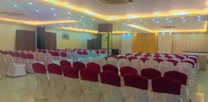 un salón de banquetes con sillas rojas y blancas. en Hotel green apple, en Visakhapatnam