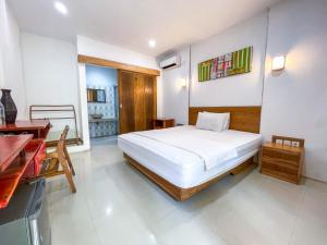 龙目岛库塔Lara Homestay的一间卧室，配有一张床、一张桌子和一张书桌
