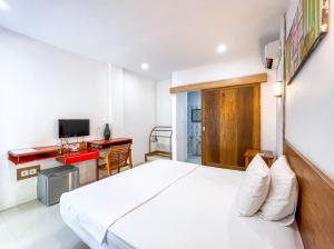 ein Hotelzimmer mit einem Bett und einem Schreibtisch in der Unterkunft Lara Homestay in Kuta Lombok