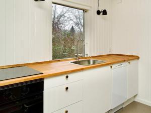 a kitchen with a sink and a window at 4 person holiday home in Holb k in Holbæk