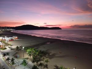 - une vue sur la plage au coucher du soleil dans l'établissement Nosso amor em paz, à Praia Grande