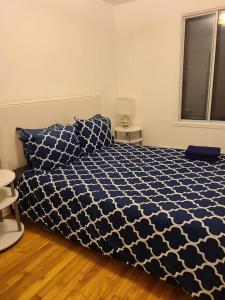 - une chambre avec une couette bleue et blanche sur un lit dans l'établissement 425$ 7nights // Full Kitchen // Room B, à Montréal