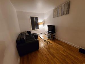 a living room with a couch and a television at 425$ 7nights // Full Kitchen // Room B in Montréal