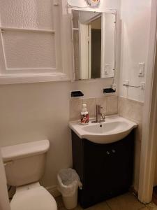 ein Badezimmer mit einem Waschbecken, einem WC und einem Spiegel in der Unterkunft 425$ 7nights // Full Kitchen // Room B in Montreal