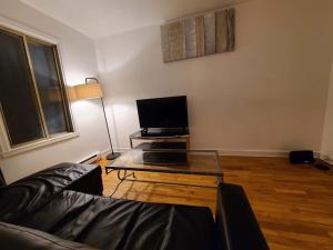 a living room with a couch and a table with a tv at 425$ 7nights // Full Kitchen // Room B in Montréal