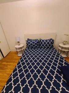 a bedroom with a blue and white bed with two tables at 425$ 7nights // Full Kitchen // Room B in Montréal