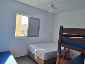 - une petite chambre avec un lit et une fenêtre dans l'établissement Nosso amor em paz, à Praia Grande