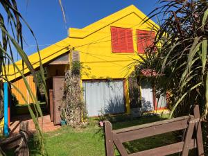 a yellow house with red shutters on it at Lobos in Aguas Dulces