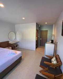 a bedroom with a bed and a bathroom with a mirror at Siri Hotel Phuket in Phuket Town