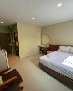 a bedroom with a large bed and a mirror at Siri Hotel Phuket in Phuket Town