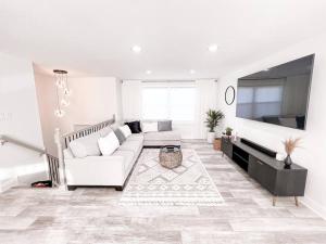 a white living room with a couch and a tv at Cozy Getaway Lodge & Retreat in Mechanicsburg