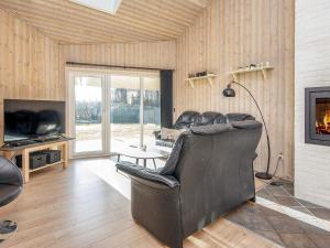 un salon avec un fauteuil en cuir et une télévision dans l'établissement 6 person holiday home in Tarm, à Tarm