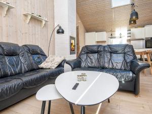 - un salon avec un canapé en cuir noir et une table blanche dans l'établissement 6 person holiday home in Tarm, à Tarm