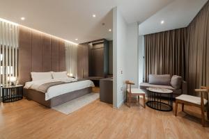 1 dormitorio con cama, sofá y mesa en Troci Hotel, en Tirana 37 fotos más