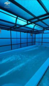 una piscina vacía con luces azules. en منتجع ديم الهدا, en Al Hada