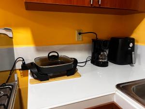 a black pot on a cutting board on a kitchen counter at Enjoy this Vacation Home close to the beach! in La Ceiba