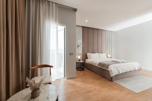 a bedroom with a bed and a glass table at Troci Hotel in Tirana