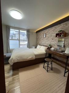 a bedroom with a bed and a brick wall at シャルムイースト in Irifunechō