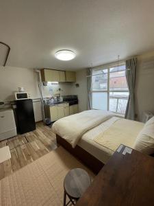 a bedroom with a large bed and a kitchen at シャルムイースト in Irifunechō