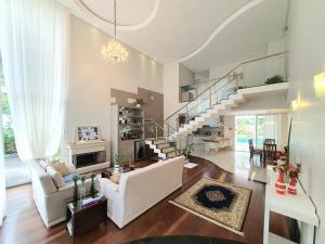 uma sala de estar com um sofá branco e uma escada em Demi-suíte privativa em casa familiar 2 em Itajaí