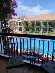 einen Tisch auf einem Balkon mit Blick auf das Wasser in der Unterkunft Plaza Del Norte Hotel and Convention Center in Laoag