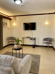 ein Wohnzimmer mit einem Sofa und einem Flachbild-TV in der Unterkunft Plaza Del Norte Hotel and Convention Center in Laoag