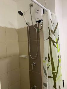 a shower with a shower curtain in a bathroom at BRENT CONDO UNIT WITH FREE PARKING & NETFLIX in Tagaytay