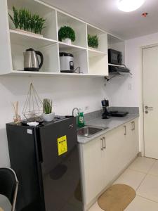 a kitchen with a black refrigerator and a sink at BRENT CONDO UNIT WITH FREE PARKING & NETFLIX in Tagaytay