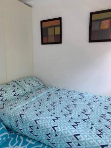 a bedroom with a bed and two pictures on the wall at BRENT CONDO UNIT WITH FREE PARKING & NETFLIX in Tagaytay