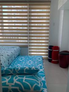 a bedroom with a bed and a window with blinds at BRENT CONDO UNIT WITH FREE PARKING & NETFLIX in Tagaytay