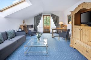 a living room with a couch and a table at Arabella Alpenhotel am Spitzingsee, a Tribute Portfolio Hotel in Spitzingsee