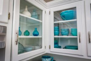 un armario de cocina lleno de jarrones de cristal azul en **Kaweah River House** - 1/2 Mile to Sequoia Park, en Three Rivers