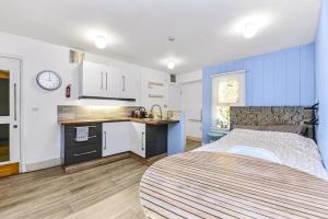 ein kleines Schlafzimmer mit einem Bett und einer Küche in der Unterkunft Cosy studio flat on a budget in London