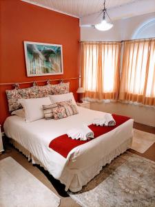 um quarto com uma cama grande e paredes vermelhas em Pousada Confraria da Terra em Campos do Jordão
