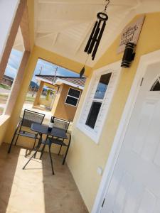 eine Veranda mit 2 Stühlen und einem Tisch vor einem Haus in der Unterkunft The Surada Bay 2 bedrooms in Old Harbour