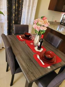 a dining room table with a red napkin and flowers at The Surada Bay in Old Harbour