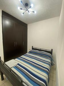 1 dormitorio con 1 cama y ventilador de techo en HERMOSA CASA PRIVADA EN FRACC VALLE VERDE, AL SUR DE LA CIUDAD., en Tapachula