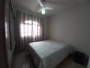 Schlafzimmer mit einem Bett und einem Deckenventilator in der Unterkunft Nossa Casa com Piscina in Guarapari