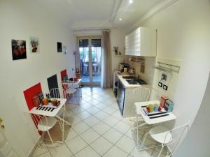 a kitchen with white appliances and white tables and chairs at Tre R in Rome