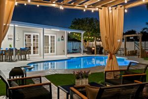 a pool with chairs and a table and a patio at Paradise Villa in West Palm Beach