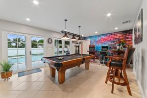 uma sala de bilhar com uma mesa de bilhar numa casa em Paradise Villa!!! Heated Pool, Games,10 min to Palm Beach & Airport em West Palm Beach