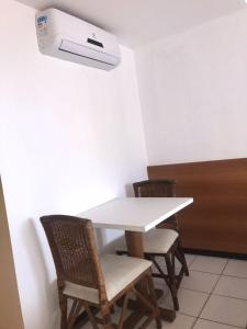 a white table with chairs and a printer on the wall at Flat Ponta Negra vista para o mar in Natal