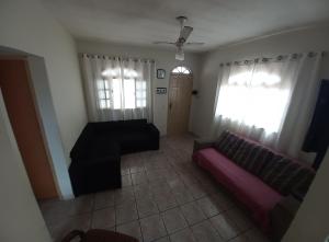 ein Wohnzimmer mit einem Sofa und einem Fenster in der Unterkunft Nossa Casa com Piscina in Guarapari