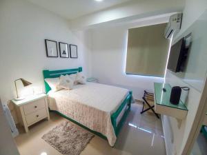 Schlafzimmer mit einem Bett und einem Flachbild-TV in der Unterkunft Bella Place in Santiago de los Caballeros