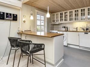 a kitchen with two chairs and a counter in a room at 8 person holiday home in R dby in Rødby