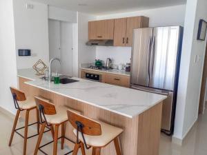 eine Küche mit einer Theke und einem Kühlschrank in der Unterkunft Bella Place in Santiago de los Caballeros