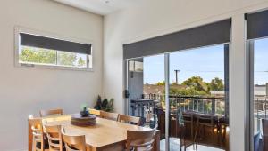 a dining room with a table and a balcony at MURRAY GRANGE VILLA 4 in Yarrawonga