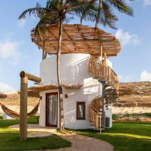 a house with a palm tree and a staircase at VentoVinte Beach Club in Flecheiras
